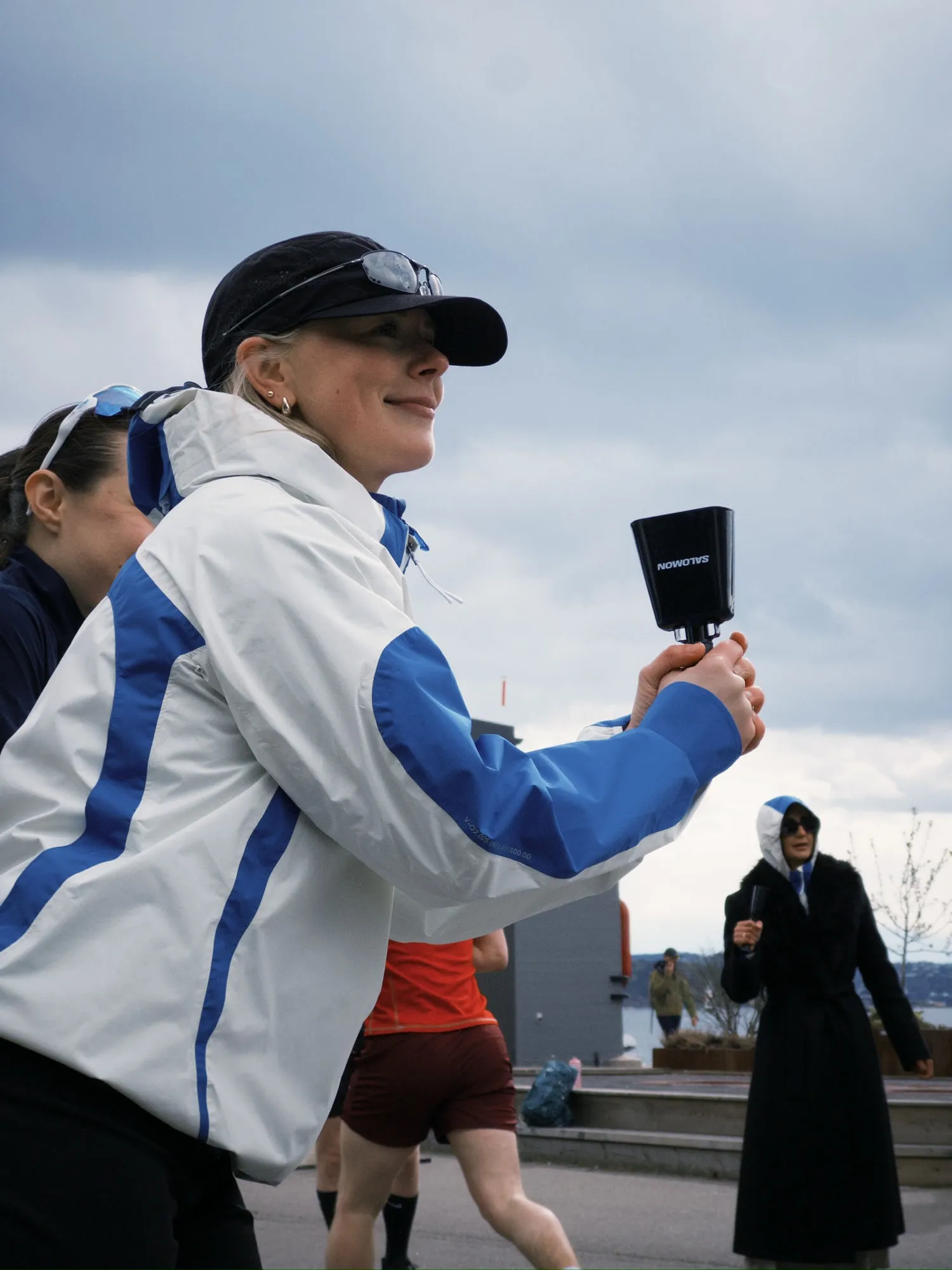 A KL member cheering on runners with a cowbell