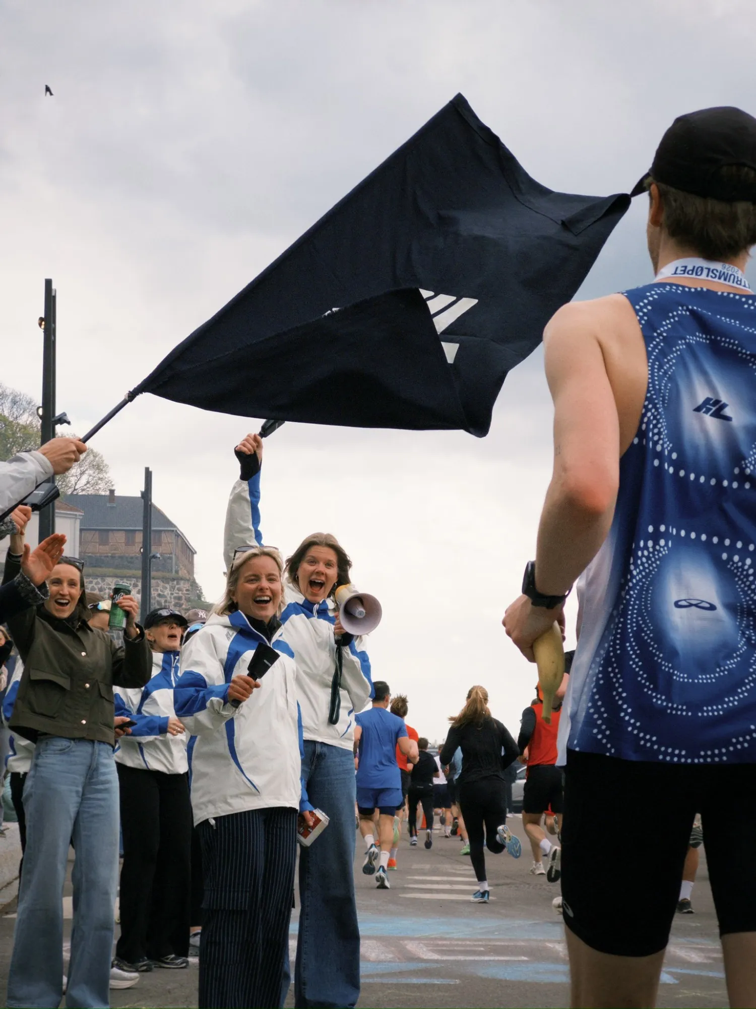 Cheering with the KL flag and megaphone as runners pass