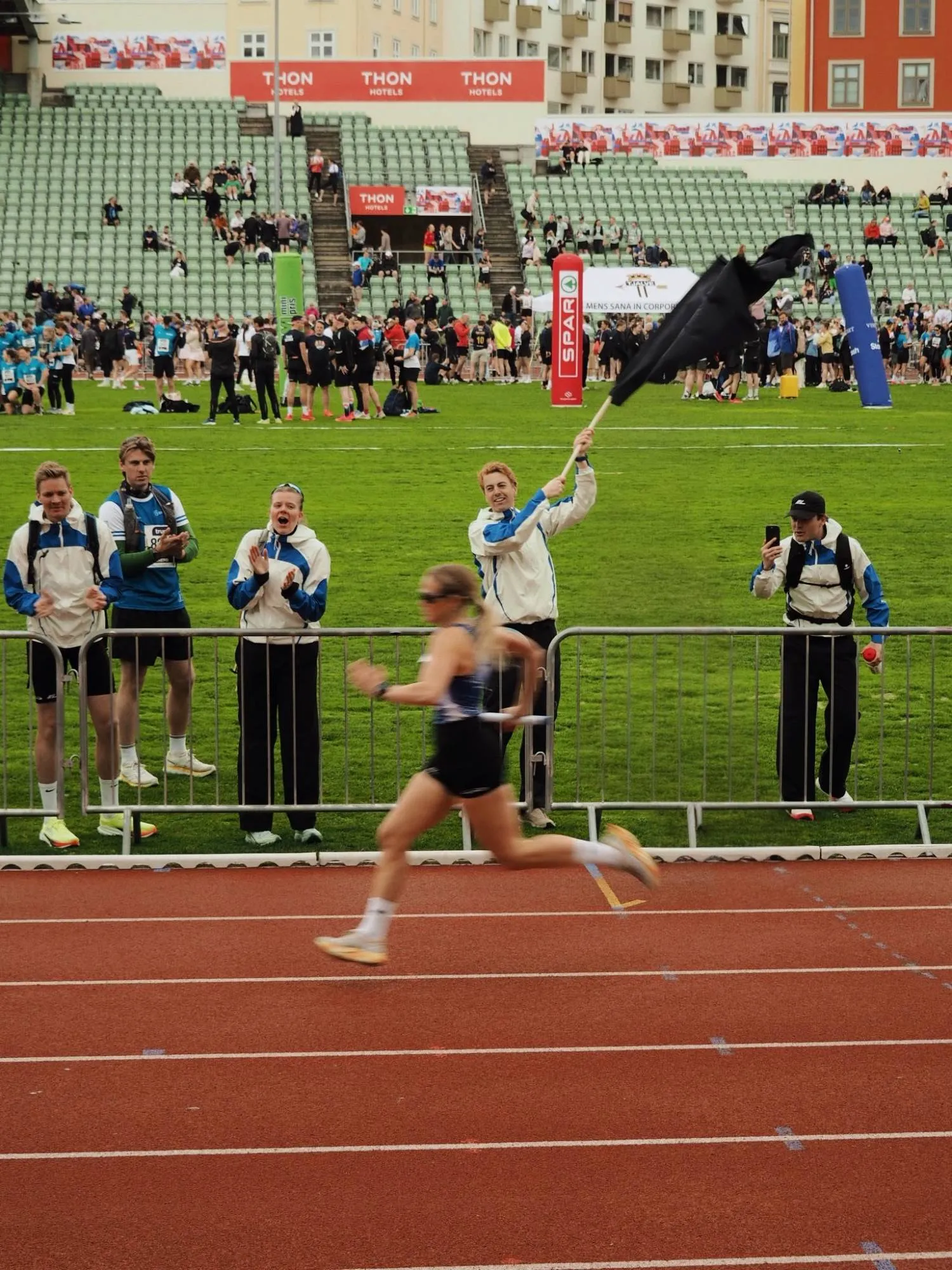 The KL crew cheering from the trackside as a runner sprints past