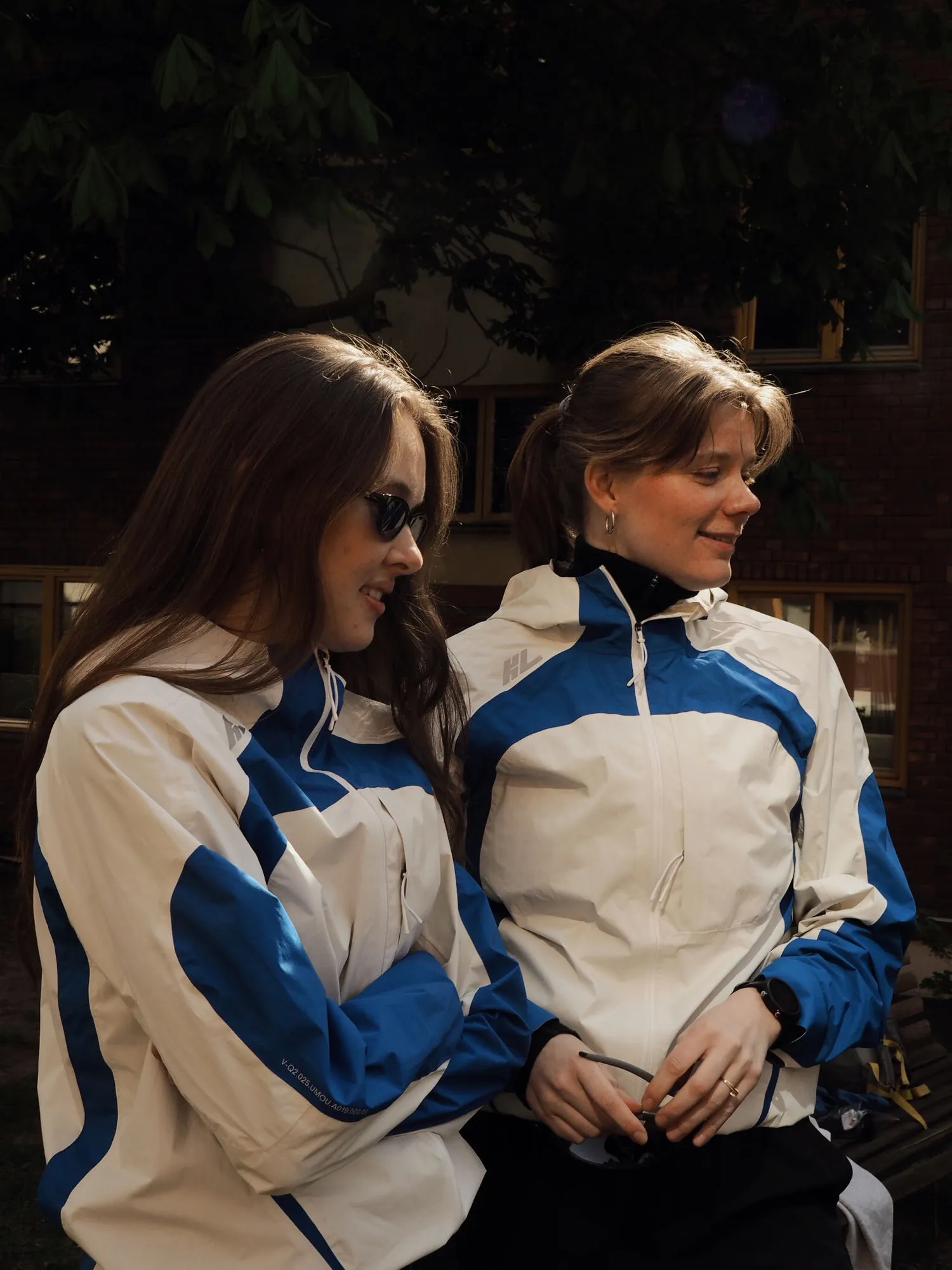 Two KL members in matching white-and-blue jackets before the start