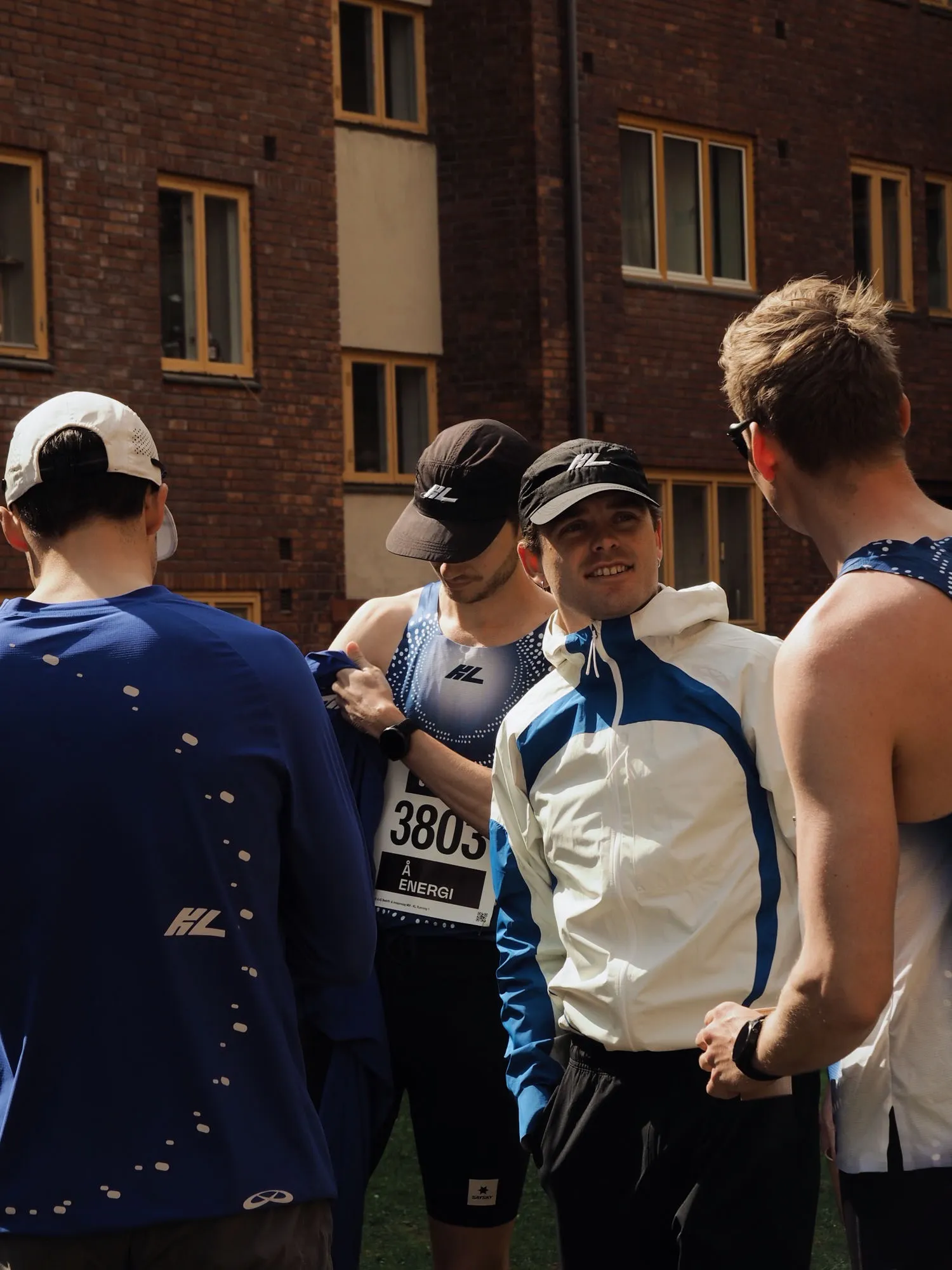 KL teammates in caps and bibs huddled together before their leg